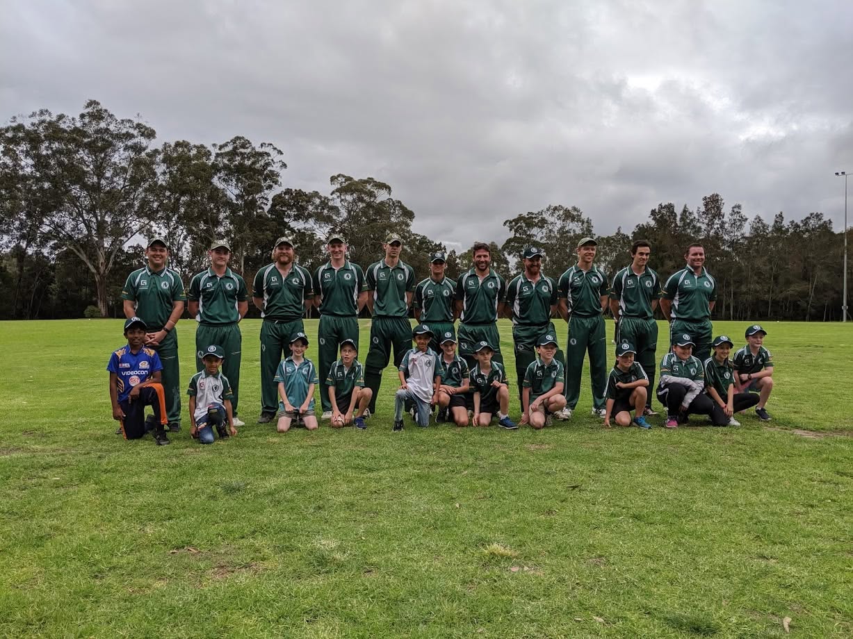 Senior men's team standing with junior players