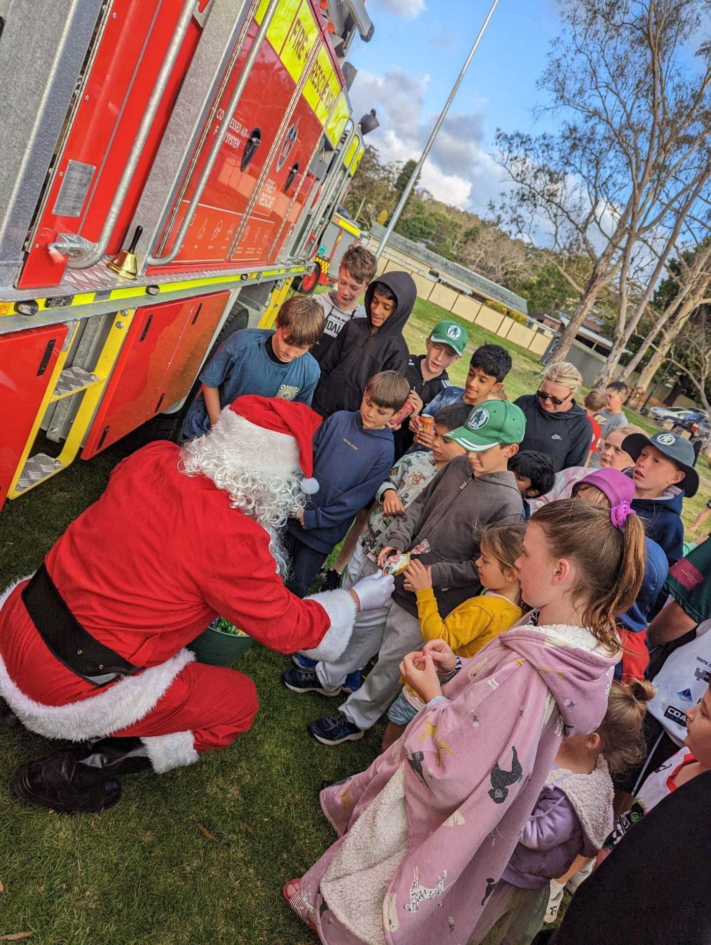Santa handing out lollies from a fire truck at the club