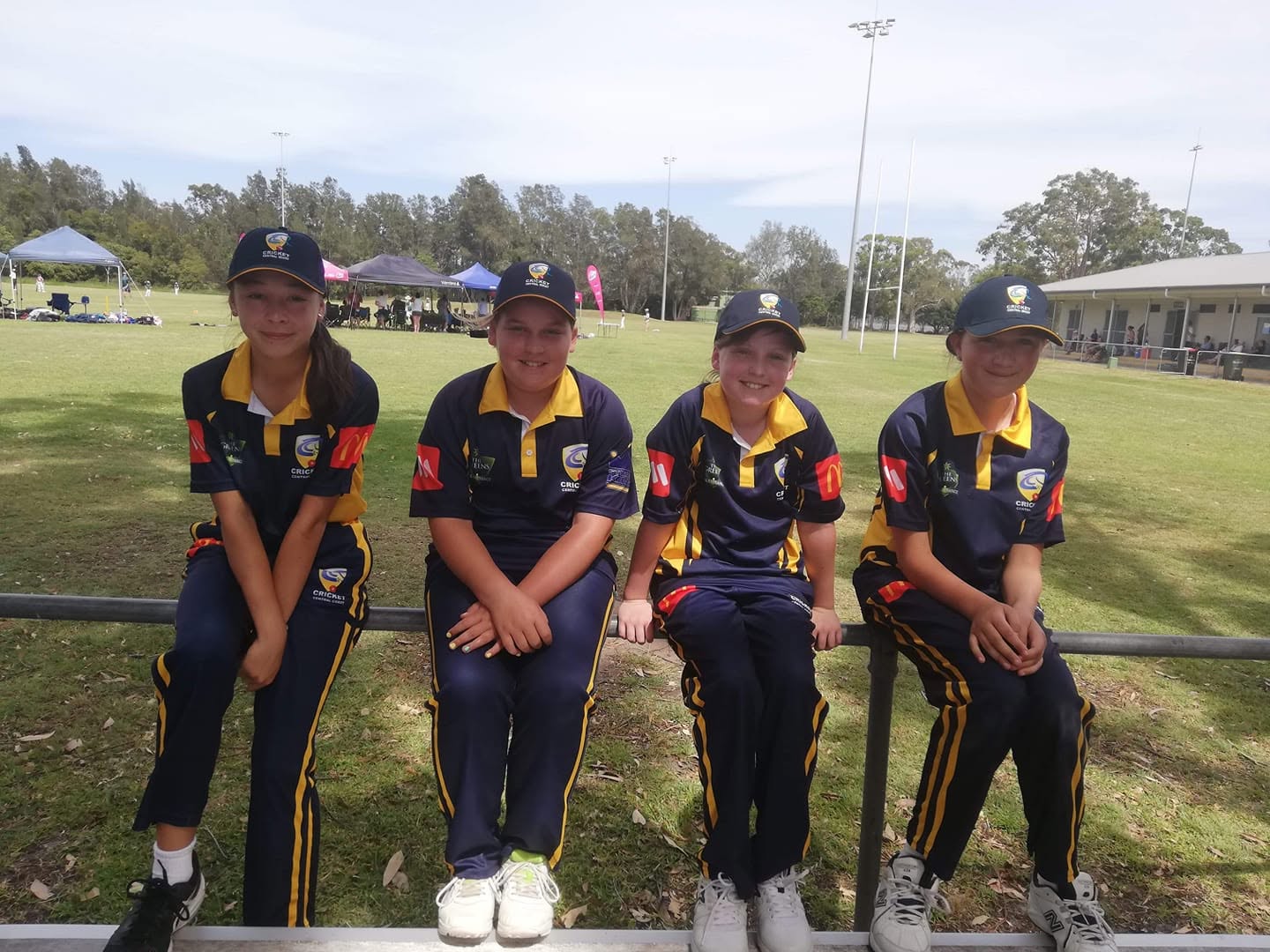 Four girls in Central Coast rep kit at the ground